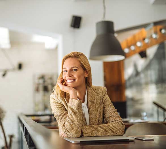 Portrait of a woman who smiles at work in an open space