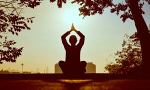 Une femme pratique le yoga au petit matin.