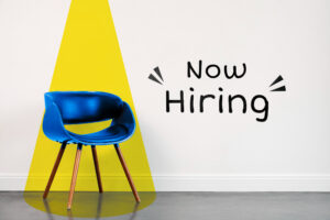 Une chaise sur laquelle est écrite "Now hiring"